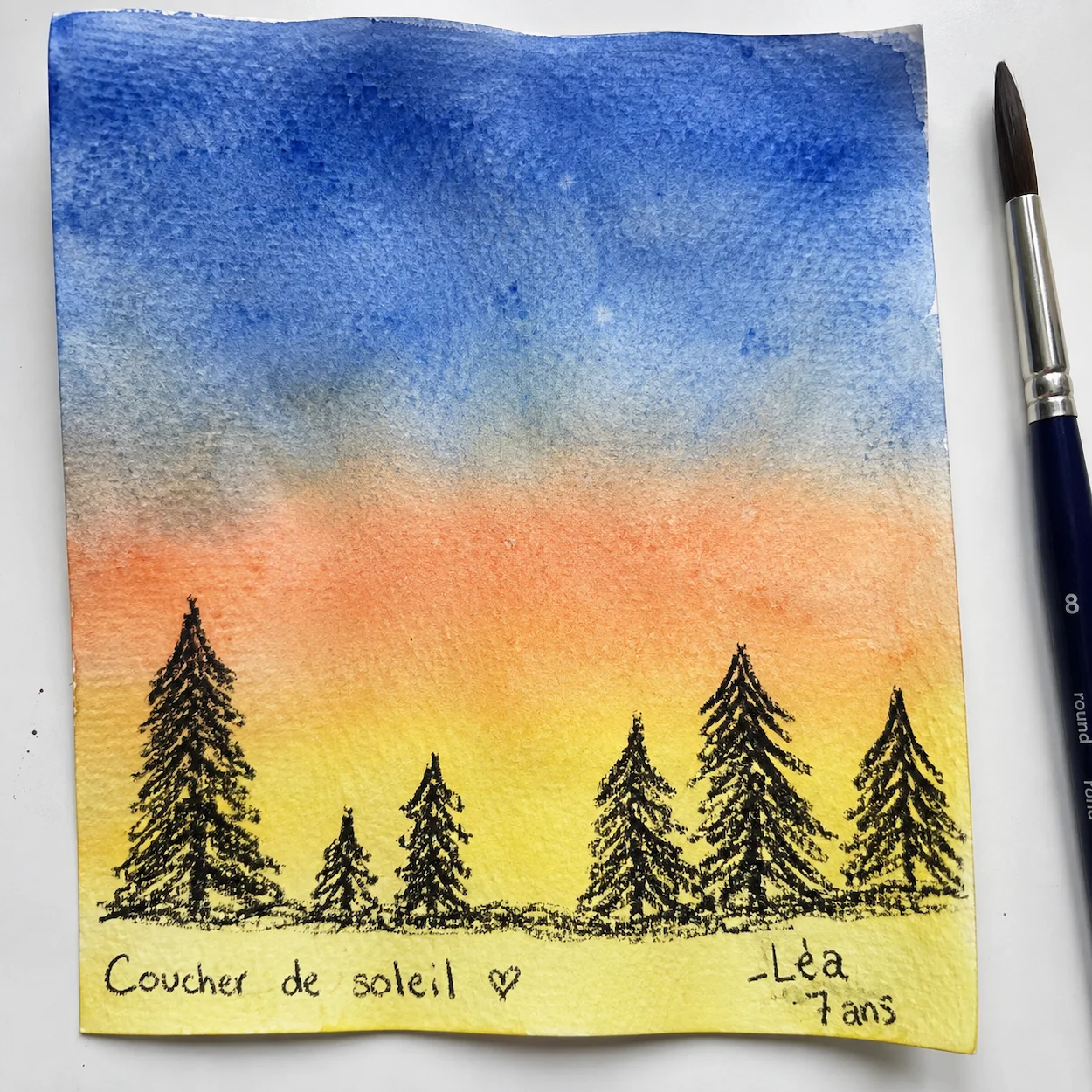 Lavis aquarelle enfant : dégradé humide-sur-humide du bleu cobalt à l'orange pêche puis au jaune citron, avec silhouette d'arbres au crayon noir dessous